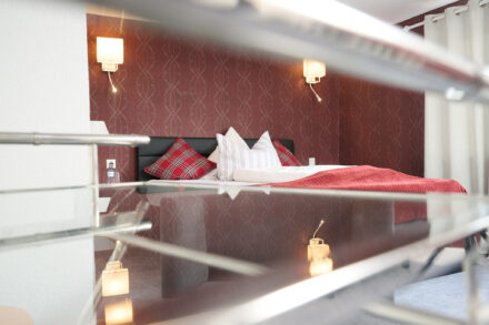 Ein Hotelzimmer mit roter Tapete und einem großen Doppelbett.